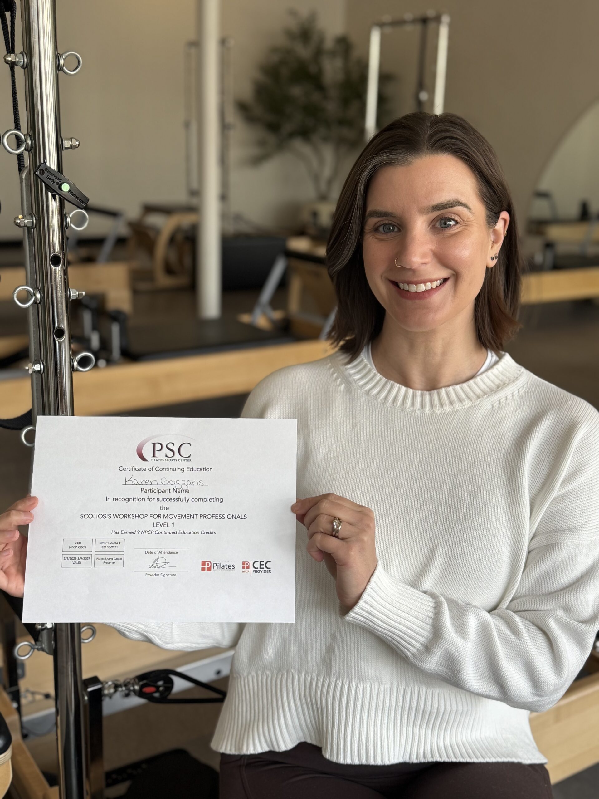 Karen holding her Scoliosis Level 1 Certificate of Completion